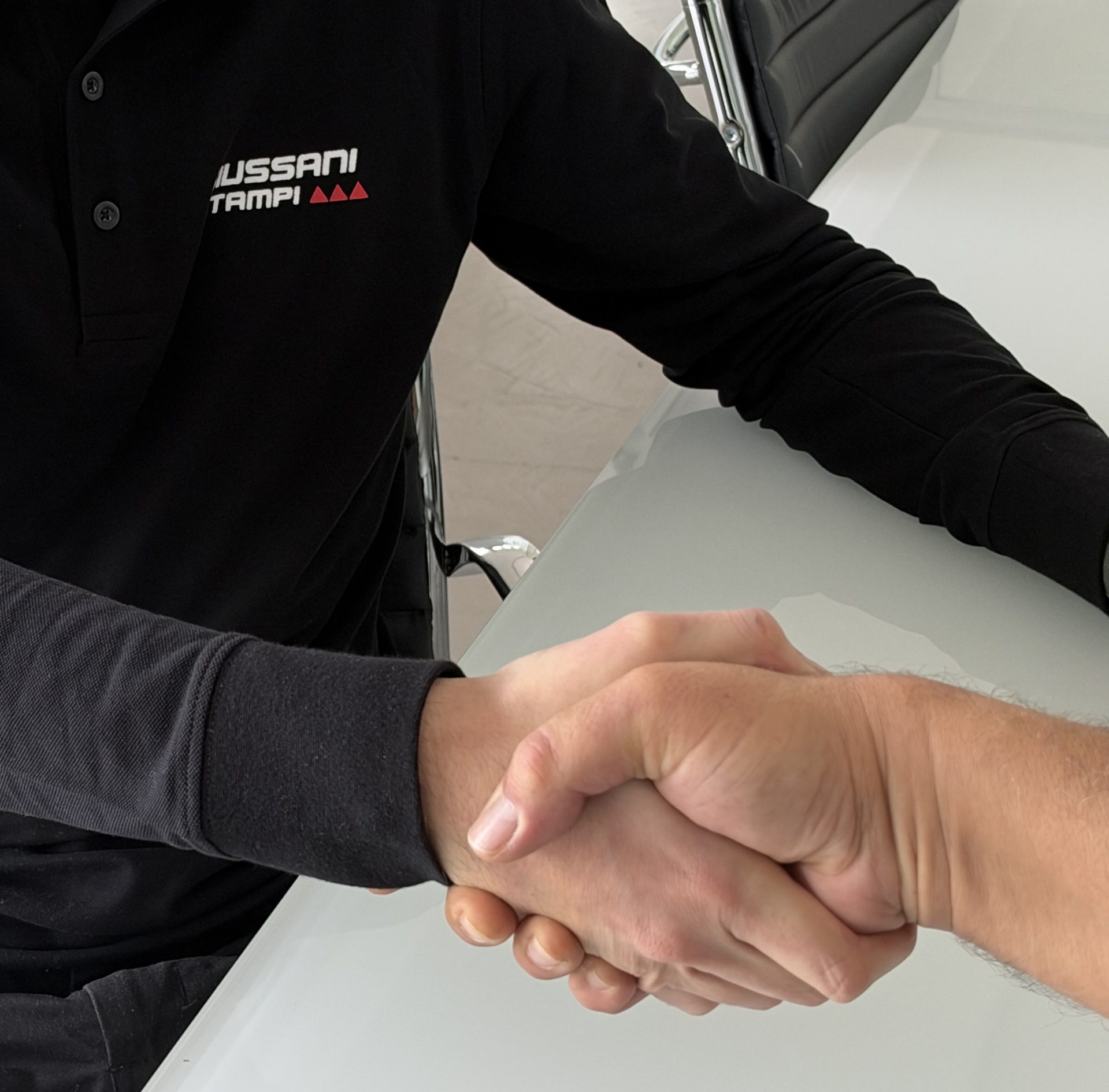 Handshake with the Giussani Stampi logo on the shirt